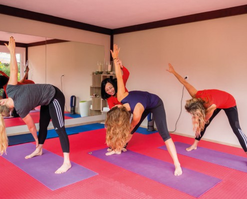 Drei Yogaschüler beim Training mit Thu.